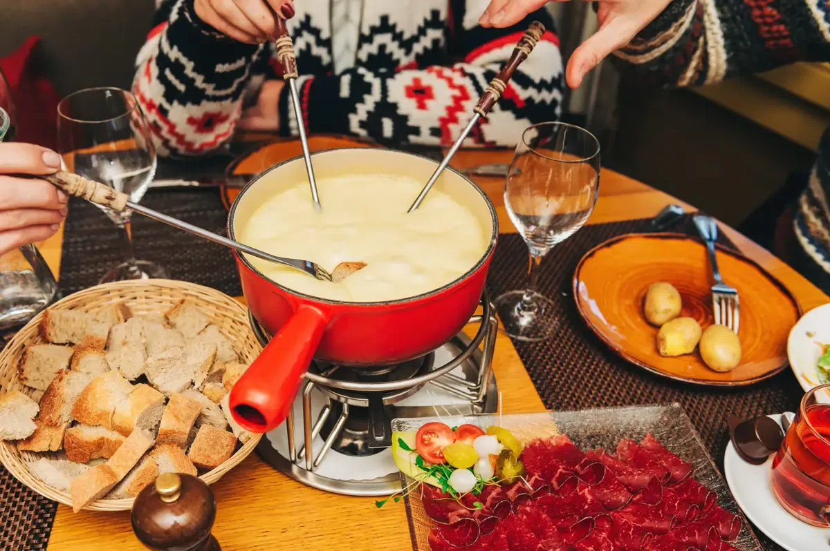 Espacio representativo del hotel: Una mesa de comedor con una olla de queso fundido y pan para mojar.
