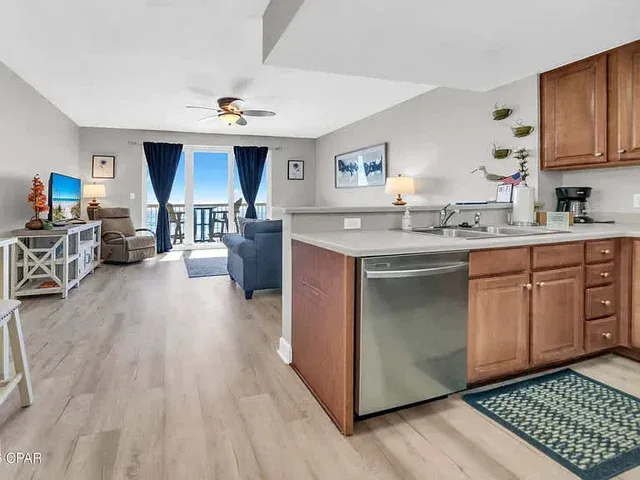 Sala de estar y cocina de concepto abierto, con una barra y zona de asientos.