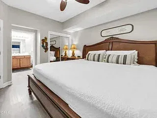 Un dormitorio con una cama grande y una puerta que da a un baño.