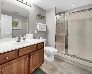 Un baño con lavabo, inodoro y ducha de vidrio.