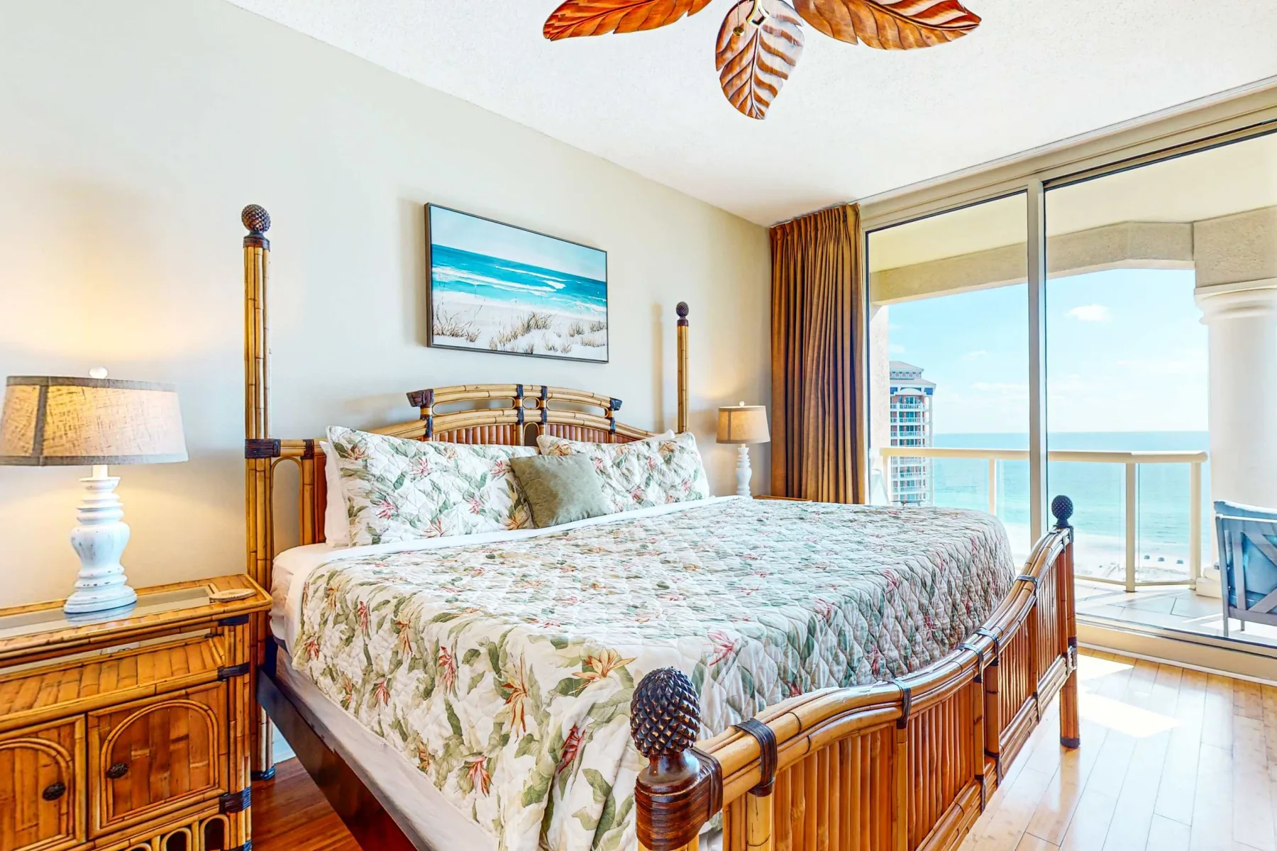 Un dormitorio con una cama de madera y grandes puertas corredizas de vidrio con vista al océano.