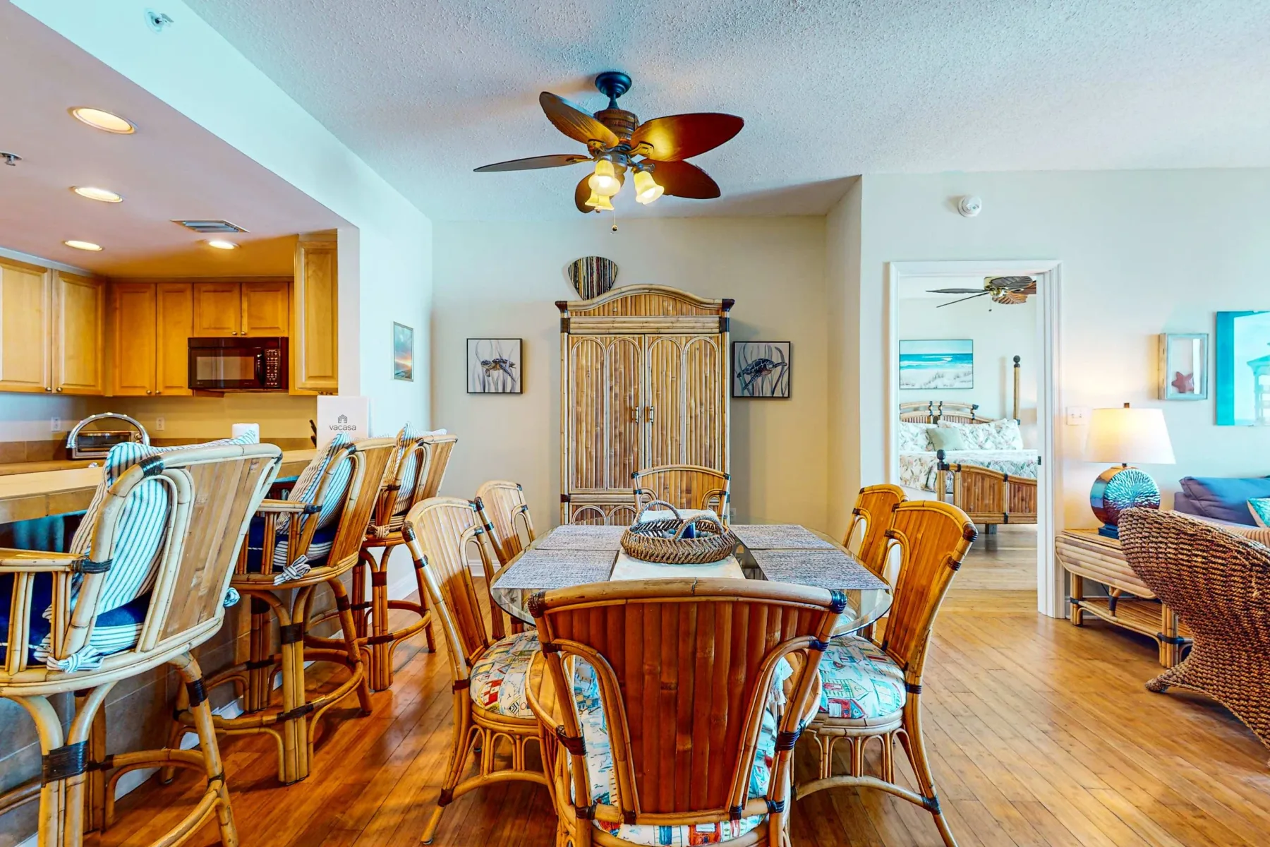 Un comedor con una mesa y sillas de madera junto a una cocina abierta.