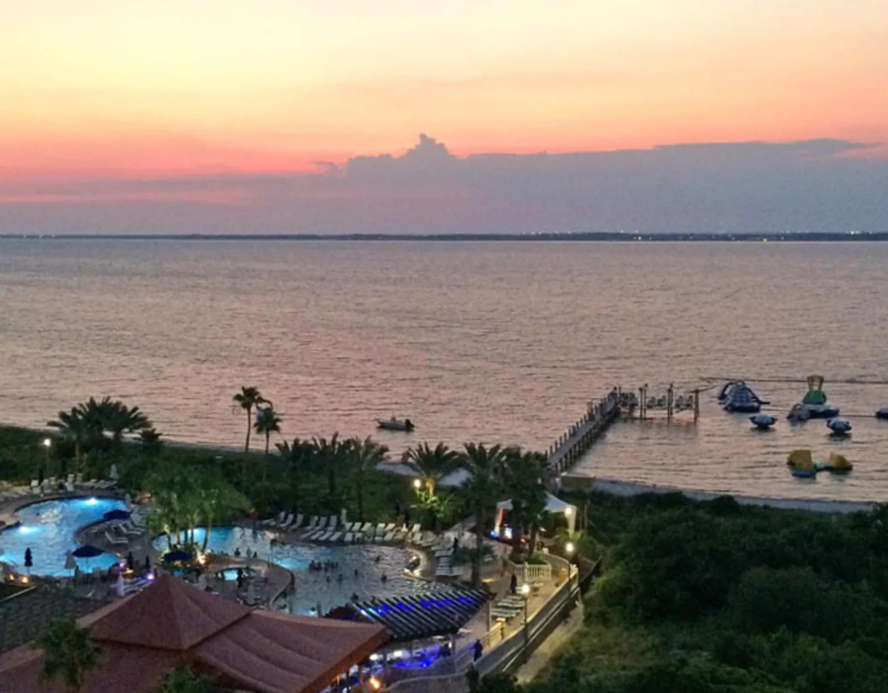 Una piscina y un muelle junto al agua se ven al atardecer.