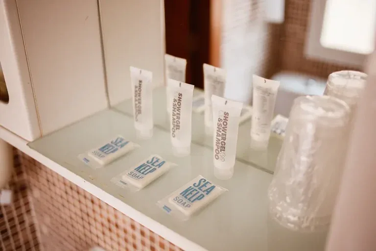 Representative hotel space: Bathroom toiletries and wrapped drinking glasses are arranged on a counter.