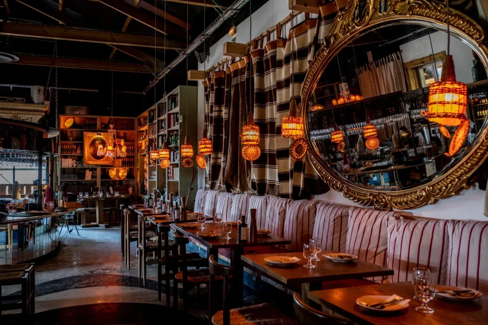 Espacio representativo del hotel: Comedor de restaurante con mesas, asientos tapizados y lámparas colgantes.