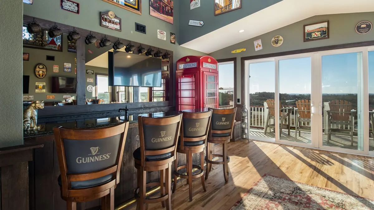 Un bar de estilo pub con asientos altos y puertas de vidrio que dan a una terraza.
