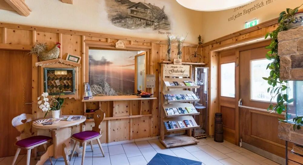 Espacio representativo del hotel: Un área de recepción revestida de madera con un expositor de folletos y un mostrador.