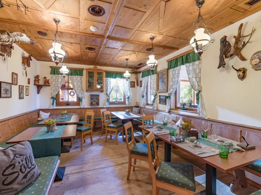 Espacio representativo del hotel: Un comedor con paneles de madera y mesas y sillas distribuidas por el espacio.