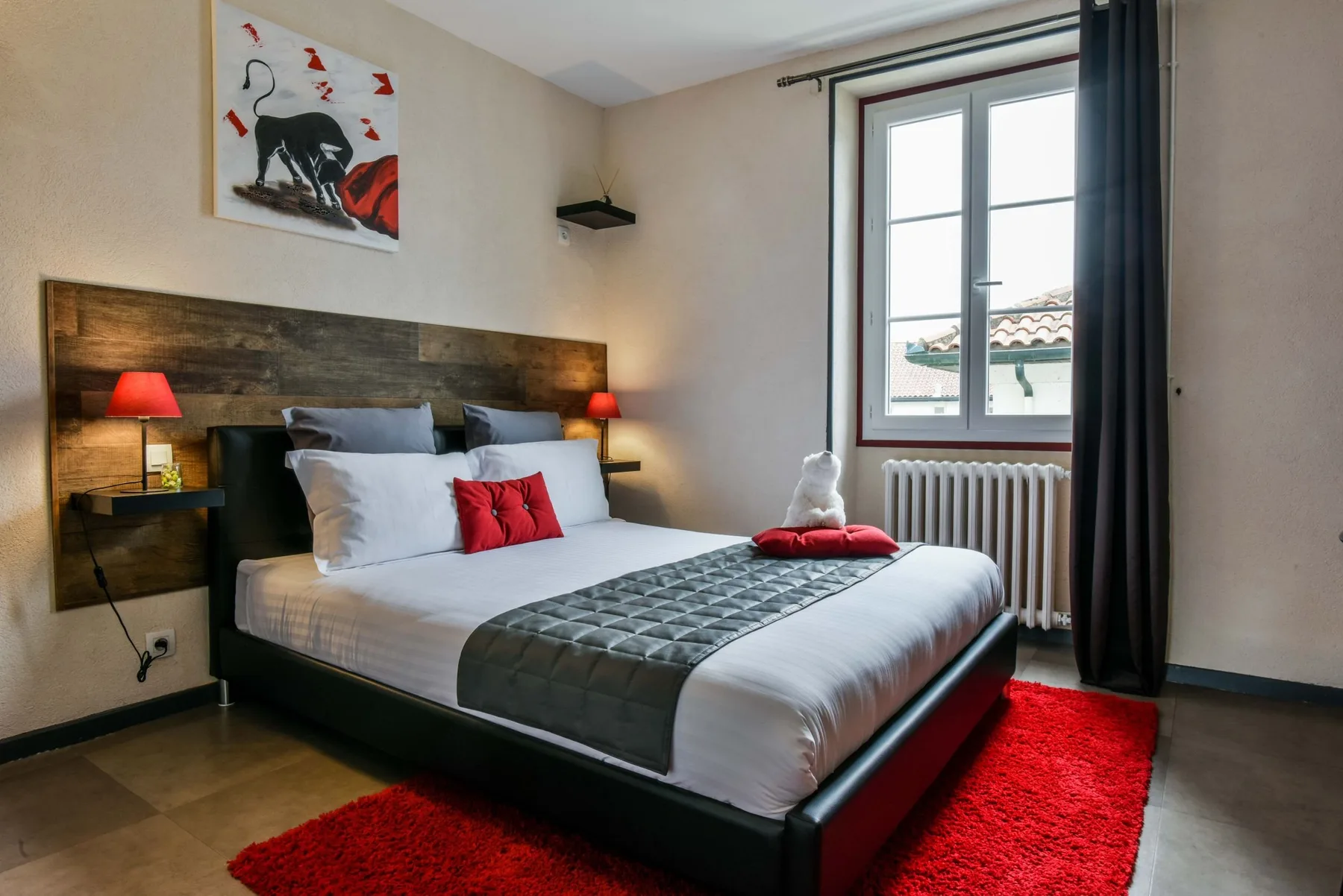 Espacio representativo del hotel: Un dormitorio con una cama bien hecha y una ventana grande.