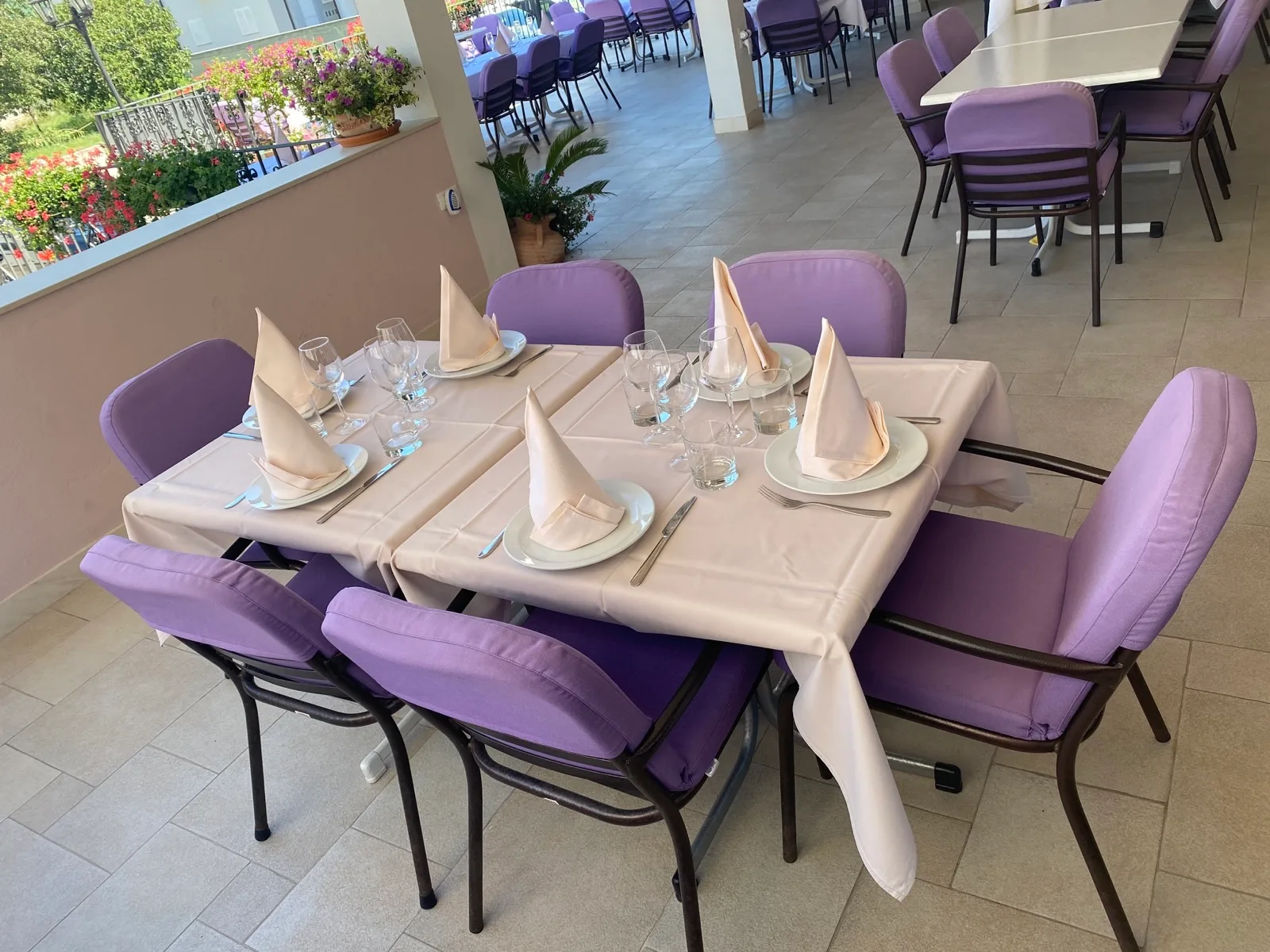 Representative hotel space: A dining area with tables set with folded napkins and glassware.