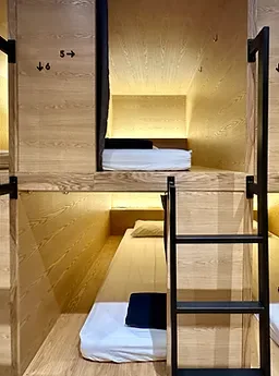 Representative hotel space: A compact sleeping area with two beds arranged in a wooden bunk structure.