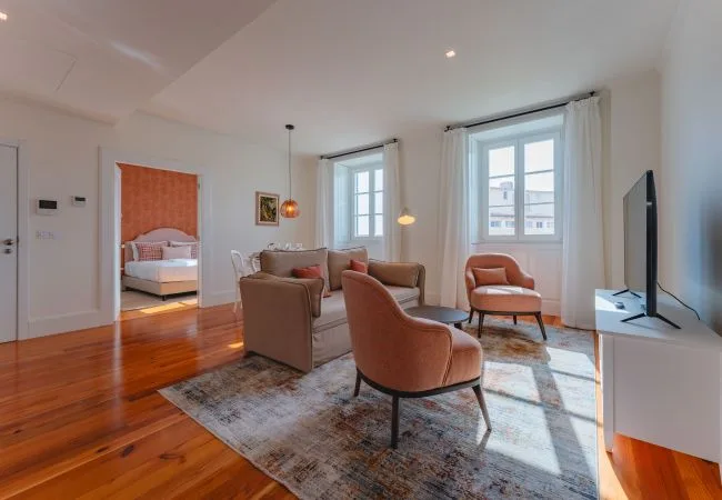 A bright living room with seating around a low table beside large windows.