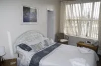 Espacio representativo del hotel: Un dormitorio con una cama junto a una ventana grande.