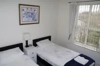 Espacio representativo del hotel: Un dormitorio luminoso con dos camas y una ventana con persianas verticales.