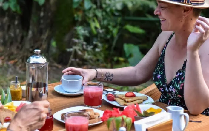 Espacio representativo del hotel: Una mesa al aire libre con comida y bebidas de desayuno entre vegetación.