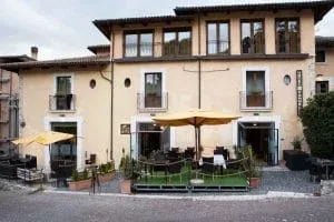 Representative hotel space: A courtyard patio with outdoor seating sits in front of a two-story building.
