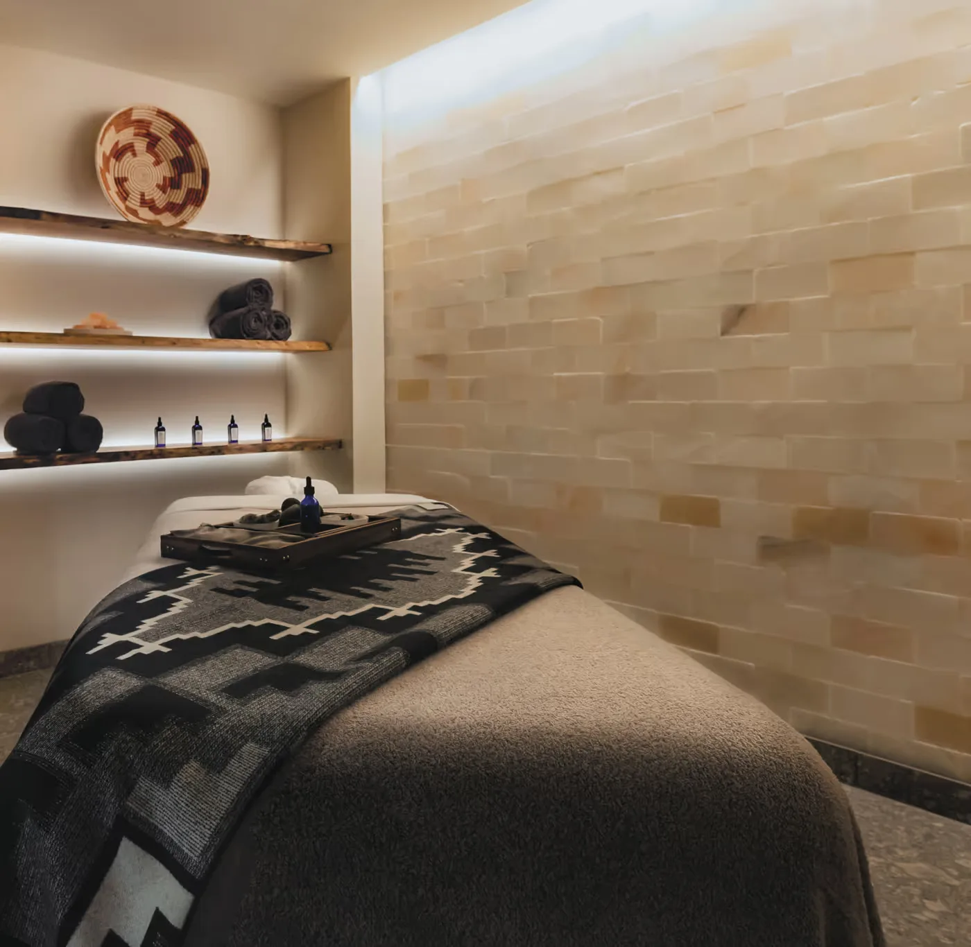 Representative hotel space: A massage table sits beside tiled walls and shelves in a treatment room.