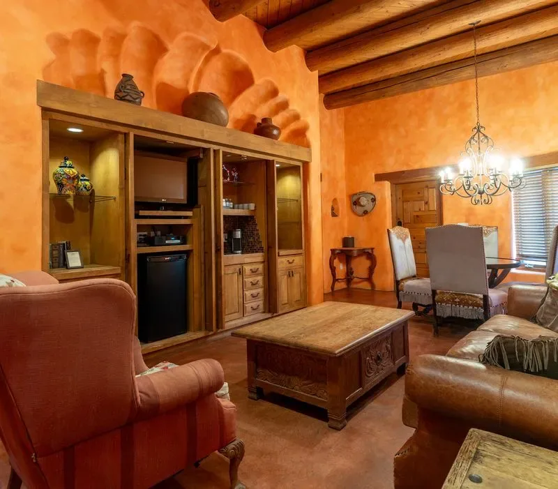 Representative hotel space: A warm-toned living room with seating, a wooden coffee table, and built-in shelving.