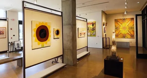 Representative hotel space: An art gallery displays framed paintings along its walls and partitions.