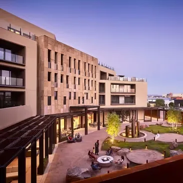Representative hotel space: A modern hotel building surrounds a landscaped courtyard with seating areas.