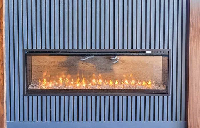 Espacio representativo del hotel: Una chimenea horizontal está integrada en una pared de listones verticales.