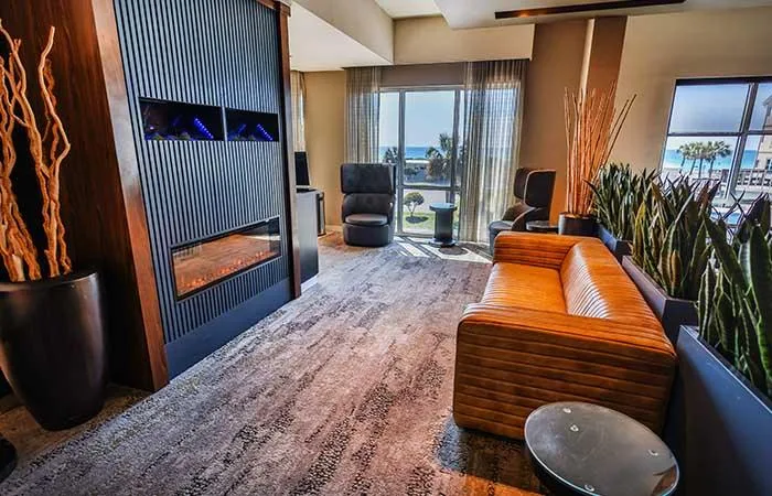 Espacio representativo del hotel: Un salón moderno de hotel con asientos y una gran ventana con vista al agua.