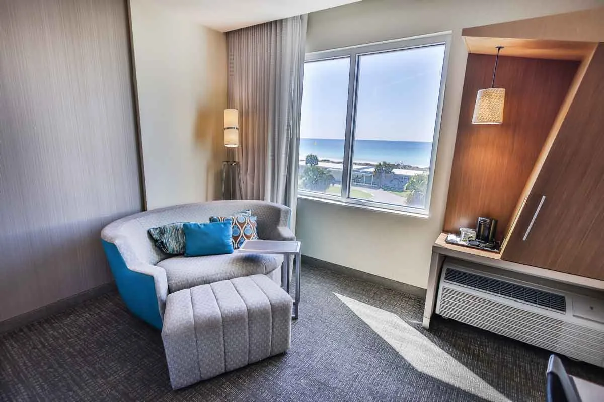 Espacio representativo del hotel: Una zona de estar de hotel con un asiento tapizado junto a una ventana amplia.