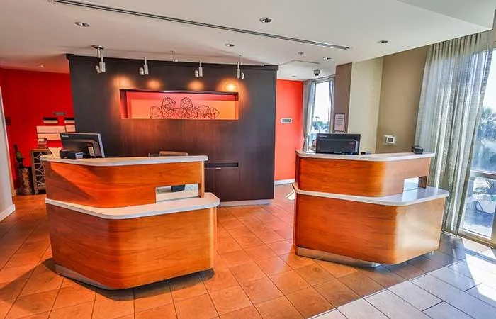 Espacio representativo del hotel: Una recepción de hotel con dos mostradores curvos de madera.