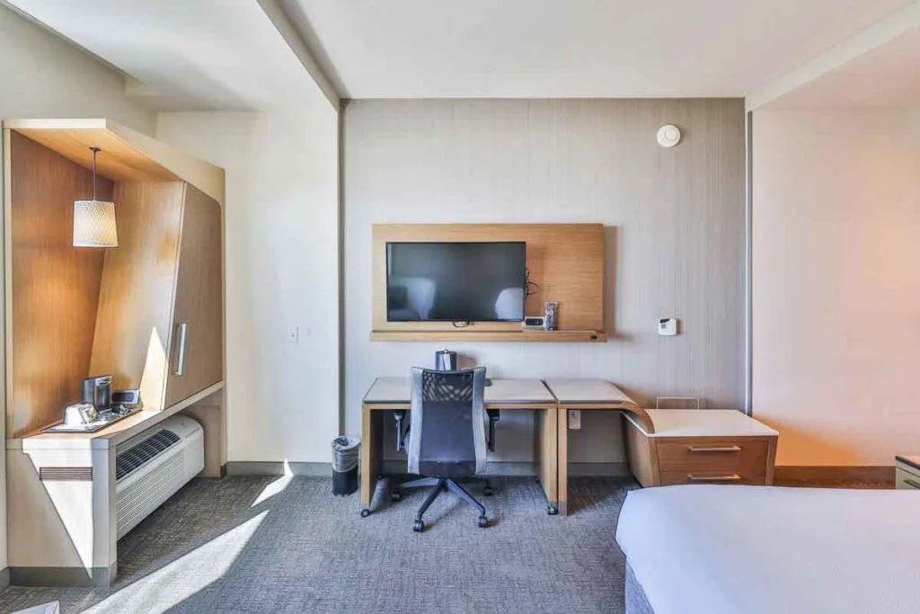 Espacio representativo del hotel: Zona de trabajo en una habitación de hotel, con escritorio, silla y televisor.