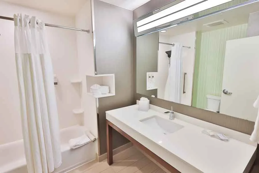 Espacio representativo del hotel: Un baño con un lavabo largo, fregadero y espejo grande.