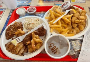 Espacio representativo del hotel: Una comida de frituras y guarniciones está dispuesta en una bandeja roja.