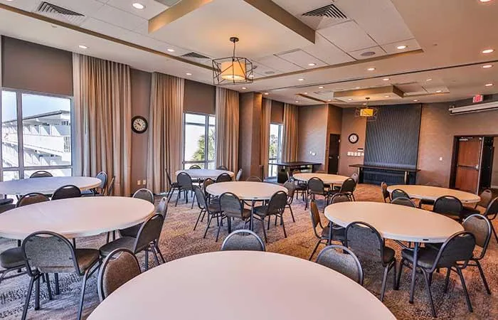 Espacio representativo del hotel: Una sala de reuniones con mesas redondas y sillas bajo luces de techo.