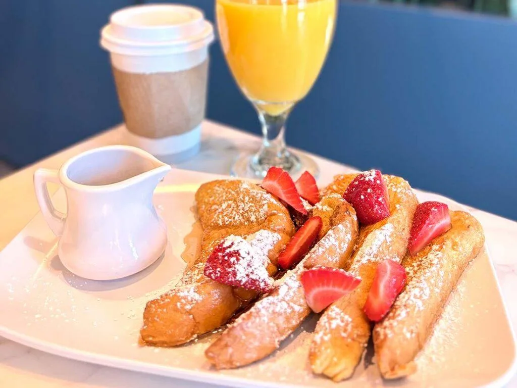 Espacio representativo del hotel: Un plato de desayuno con bollería y fresas está junto a zumo de naranja y café.
