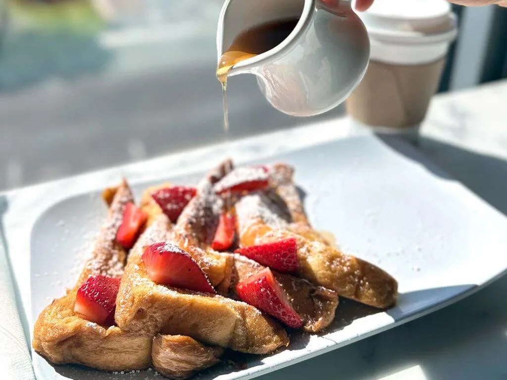 Espacio representativo del hotel: Tostadas francesas con fresas mientras se vierte sirope sobre el plato.