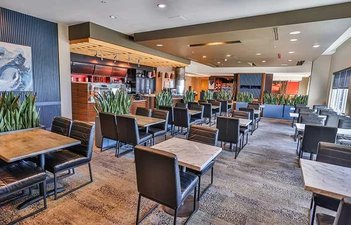 Espacio representativo del hotel: Un comedor de restaurante con mesas y asientos.