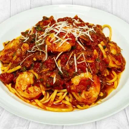 Espacio representativo del hotel: Un plato de pasta con salsa roja, camarones y queso rallado.