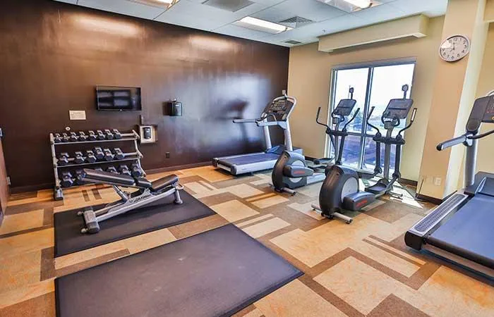 Espacio representativo del hotel: Sala de ejercicio de un hotel con máquinas y pesas.