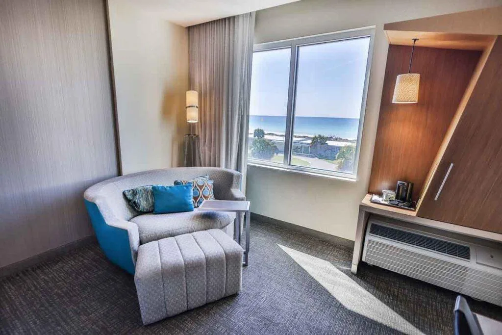 Espacio representativo del hotel: Una zona de estar de una habitación da a una ventana amplia con vistas al agua.