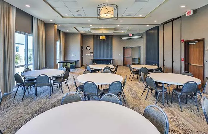 Espacio representativo del hotel: Una sala de reuniones con mesas redondas y sillas distribuidas por el espacio.