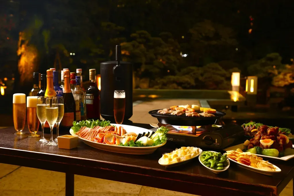 Espacio representativo del hotel: Mesa de comedor al aire libre con bebidas, aperitivos y un calentador de buffet.