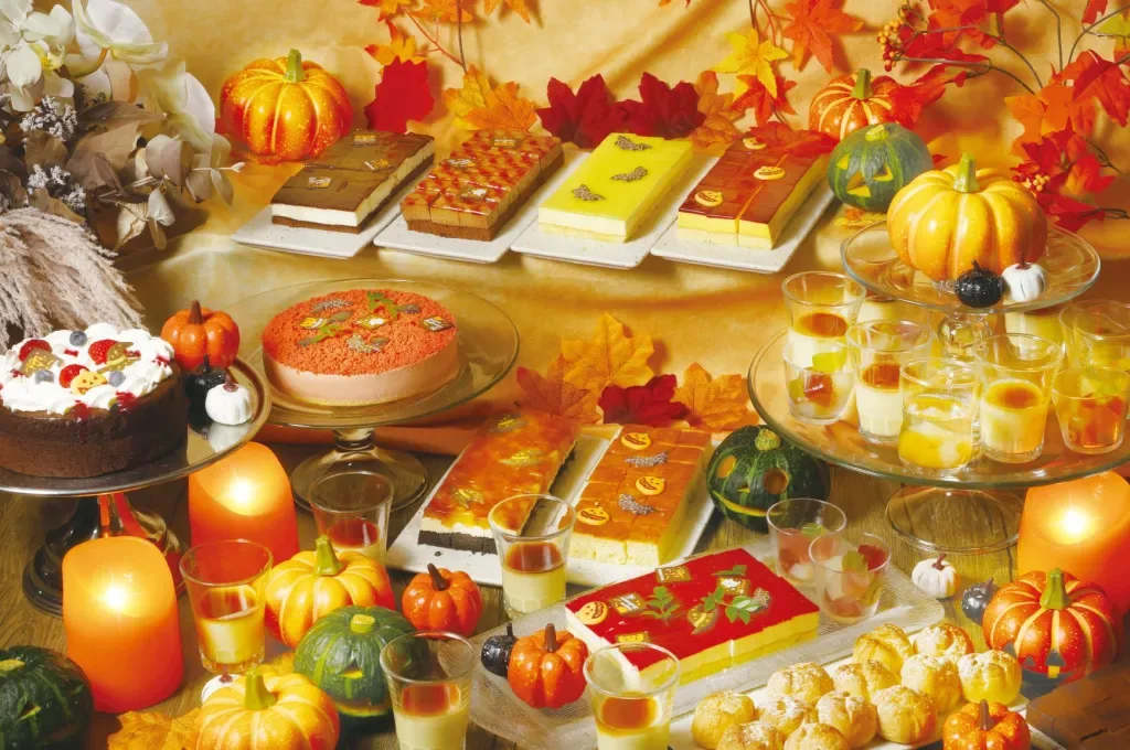 Espacio representativo del hotel: Una mesa de postres presenta pasteles, repostería y pequeños vasitos de postre.