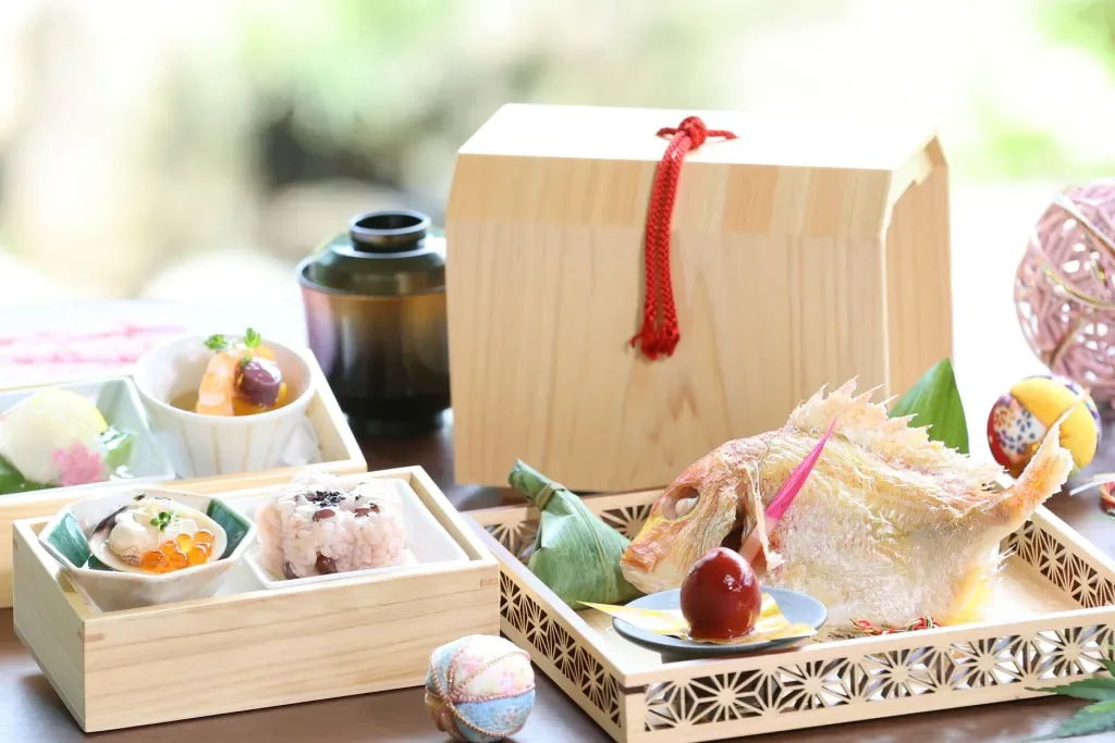 Espacio representativo del hotel: Una comida japonesa está dispuesta sobre una mesa con una caja de madera y varios platos.
