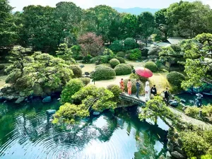 Espacio representativo del hotel: Un jardín paisajístico rodea un estanque, con un pequeño puente que cruza el agua.