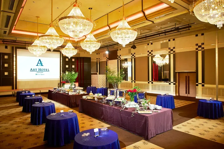 Espacio representativo del hotel: Un salón de banquetes de hotel está dispuesto con mesas de buffet y mesas redondas.