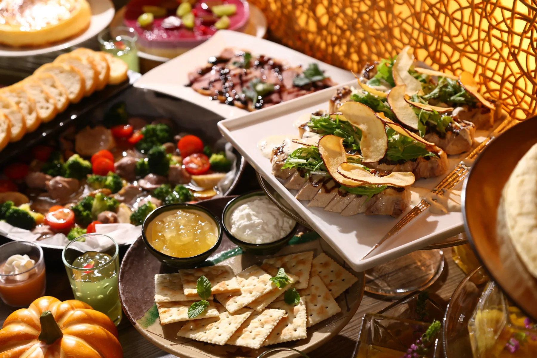 Espacio representativo del hotel: Una mesa de bufé presenta ensaladas variadas, salsas, panes y platos preparados.