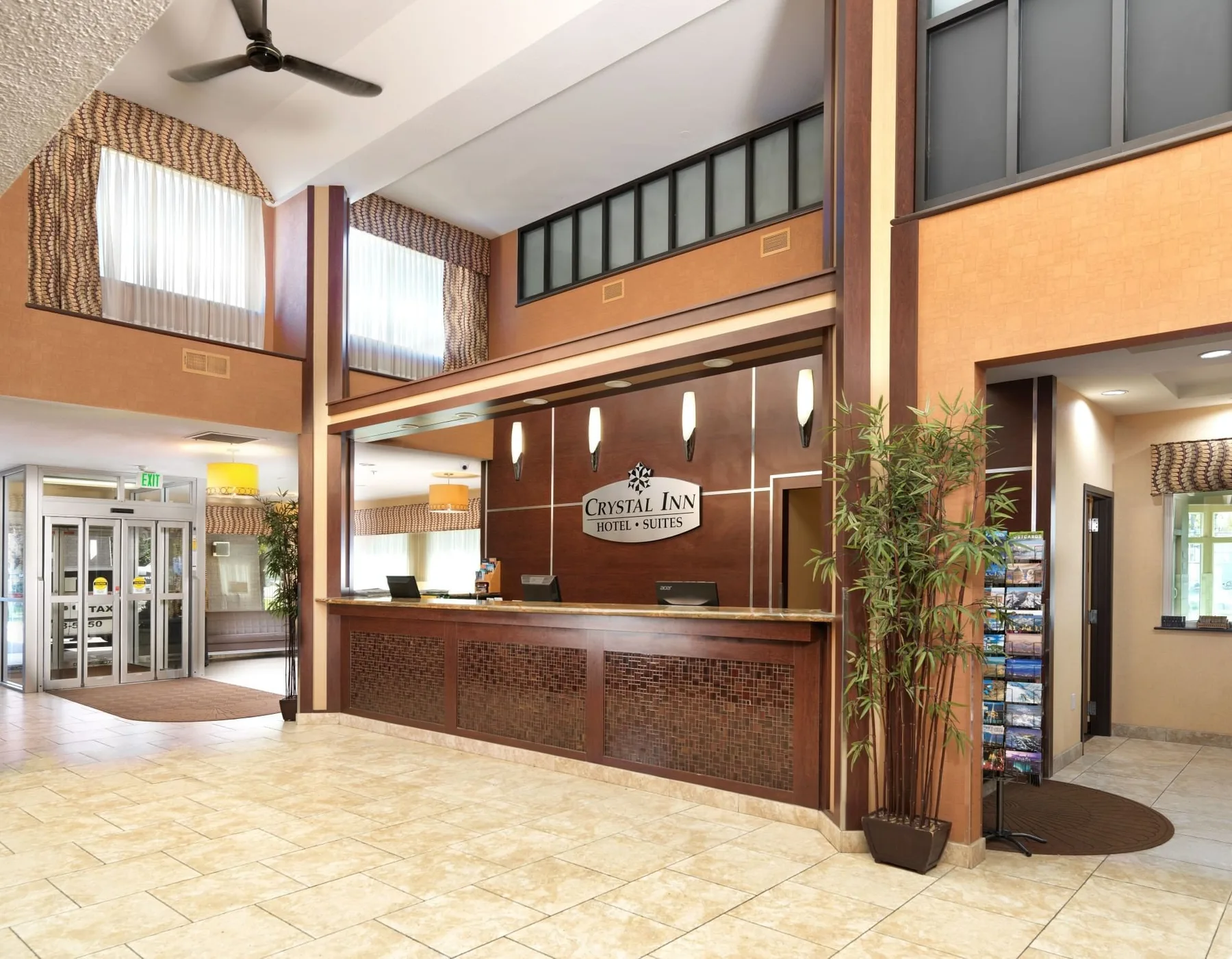 Espacio representativo del hotel: Vestíbulo de hotel con mostrador de recepción y un pasillo con ventanas en la parte superior.