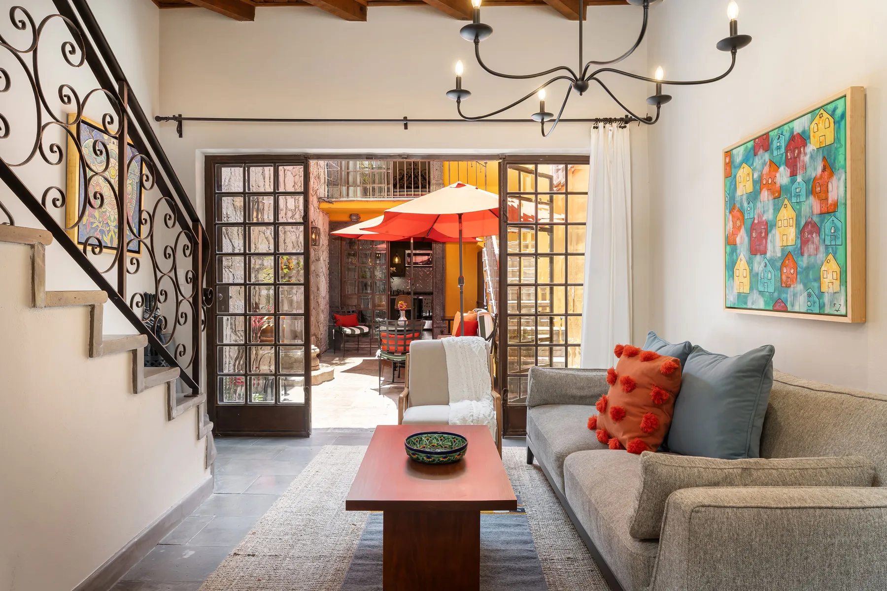 A living room with a sofa, coffee table, and open doors to a patio.