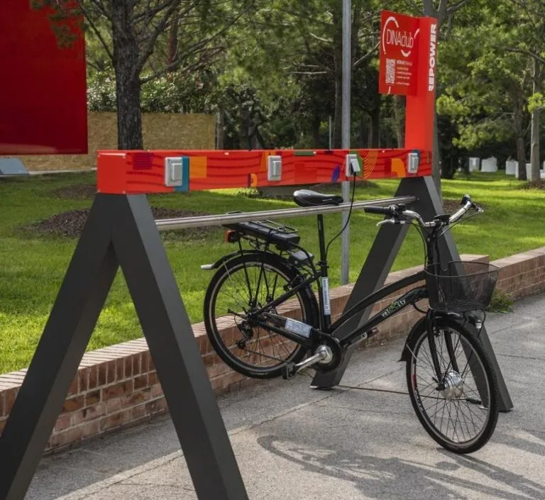 Representative hotel space: A bicycle is parked beside a red bike-sharing station on a paved path.