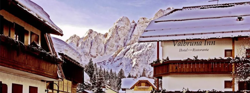 Representative hotel space: A mountain inn with snow-covered peaks rising behind it.