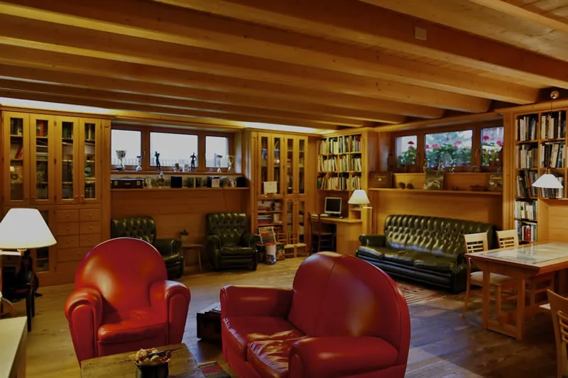 Representative hotel space: A wood-paneled library lounge with bookshelves, seating, and a wooden ceiling.